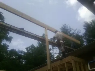 Carpenter setting a ridge beam over a new addition frame — Ice Dam Removal by Roofing Brothers in South Salem